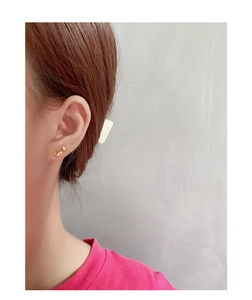 Close-up of gold irregular geometric S925 silver stud earrings worn on earlobe