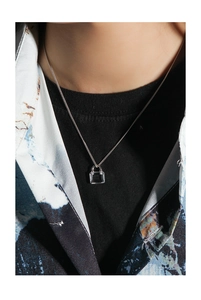 Detail shot of a minimalist silver pendant necklace with clear cubic zirconia on a model