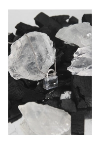 Macro detail of S925 silver necklace with rectangular zircon padlock pendant on crystals