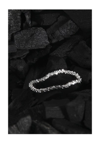 Macro shot of shimmering S925 sterling silver star-like necklace on charcoal texture