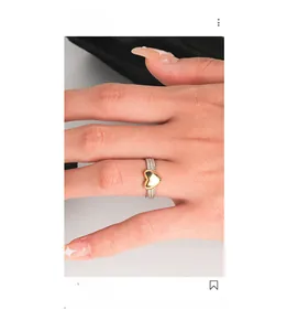 Close-up of S925 sterling silver twisted ring with a gold heart pendant detail
