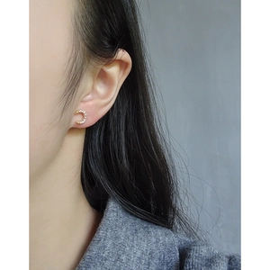 Elegant gold crescent moon stud earrings with sparkling crystals worn on ear