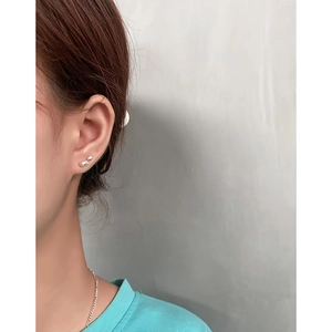 Minimalist S925 sterling silver bean stud earrings worn on earlobe for casual style