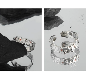 Detailed macro of irregular S925 silver ring texture with micro-set red zircons