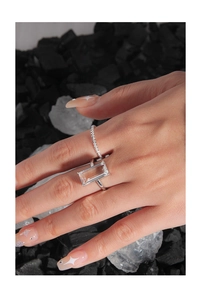 Macro shot of minimalist silver rings with rectangular cut stone and pavé details