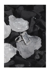 Macro detail of a 925 silver ring featuring a large rectangular zircon on dark minerals