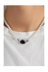 Close-up of pearl necklace featuring a black onyx pendant with sparkling crystal halo