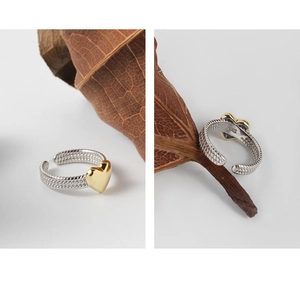 Macro shot of S925 sterling silver twisted ring band with a golden heart detail