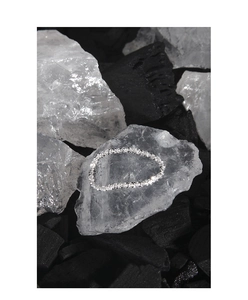 Macro shot of shimmering S925 sterling silver chain ring on white crystal stones