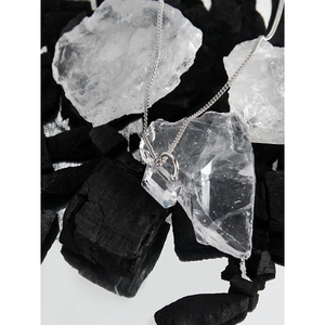 Minimalist S925 silver necklace with a clear geometric zircon lock pendant on dark stones