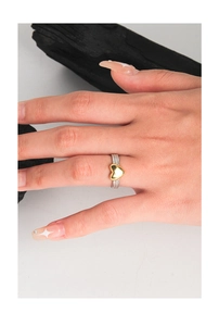 Macro detail of S925 silver braided band ring with a polished golden heart charm