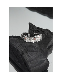 Macro detail of irregular lava texture silver ring with micro-set red zircon stones