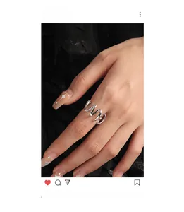 Macro detail of a minimalist wave-shaped S925 sterling silver ring on a finger