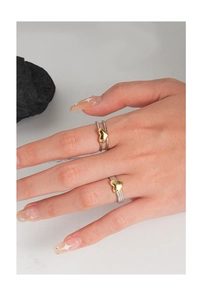 Detail of silver double-layer rings with 3D gold hearts on model's fingers