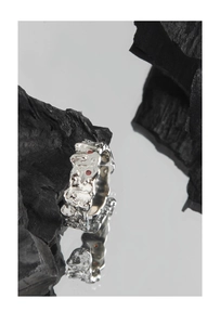Macro detail of irregular S925 silver texture ring with red zircon stone accents