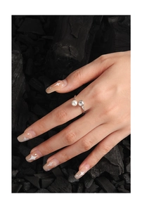Detail eines S925 Silberrings mit Perle und Strass auf einer Hand mit Sternen-Nageldesign