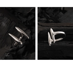 Macro di anello aperto minimalista in argento S925 su sfondo di legno scuro testurizzato