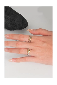 Detail of layered S925 silver rings with gold heart accents on a model's hand