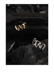 Macro shot of wavy S925 sterling silver rings in gold and silver finish on black wood