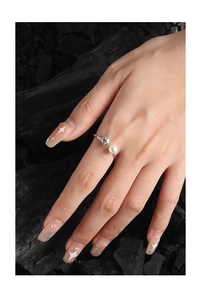 Nahaufnahme S925 Silberring mit Perle an Modelhand vor dunklem Hintergrund mit Felsstücken
