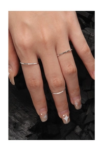 Macro detail of three 1mm S925 sterling silver rings with textured vertical patterns