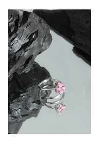 Detail of S925 sterling silver ring with pink heart-shaped zircon on reflective surface