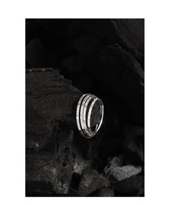 Macro detail of silver 925 textured ring with 1mm carved pattern on black coal background
