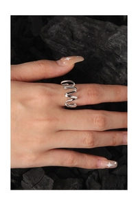 Close-up of polished S925 sterling silver wave ring on finger against black charcoal background