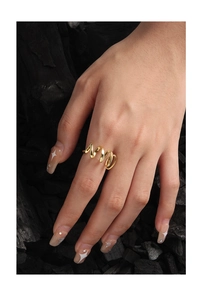 Detail of a minimalist gold wavy spiral ring with a high-polished finish on charcoal