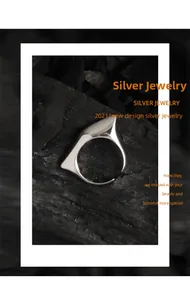 Macro shot of S925 sterling silver ring with asymmetric geometric design on black coal