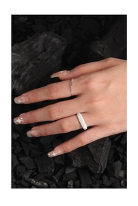 Close-up of 1mm textured S925 sterling silver rings on hand with a dark aesthetic background