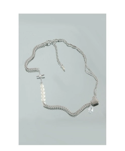Detail of silver S925 necklace with heart, cross, pearls and crystal on mirror