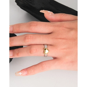 Minimalist S925 sterling silver twist ring with a gold heart detail on a woman's finger