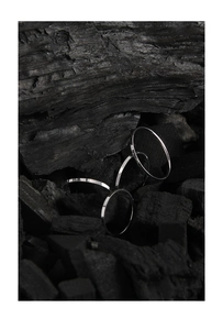 Macro detail of silver 1mm textured ring with vertical knurling on black charcoal background