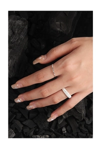 Detailed shot of silver textured rings on charcoal showing vertical grooves and frosted finish