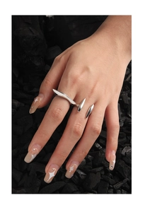 Detail of minimalist silver irregular multi-finger ring on a black charcoal background