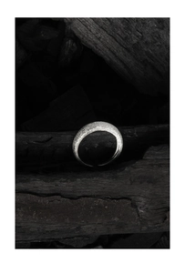 Macro detail of a minimalist S925 sterling silver ring with a textured sandblasted finish