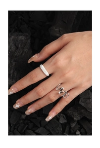 Detailed view of matte sandblasted and spiral silver S925 rings on a textured background