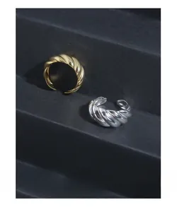Detail of minimalist gold and silver croissant rings on a modern black tiered display