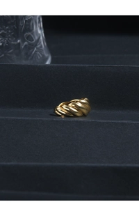 Detailed view of a French retro gold-plated textured croissant ring on a dark pedestal