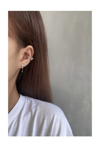 Detail of silver asymmetric liquid heart stud earring and gem-set ear cuff on ear