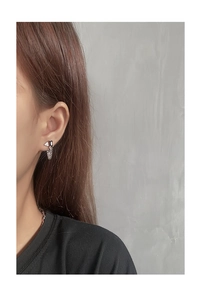 Macro detail of S925 silver earring with black zircon stone and delicate chain tassels