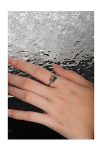 Nahaufnahme eines S925 Silberrings mit smaragdgeschliffenem blauen Zirkon am Finger