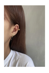 Detail of minimalist gold liquid heart stud earring and double ear cuff on model ear