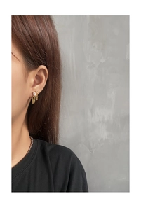 Detail view of gold S925 sterling silver chain earrings with square zircon on model