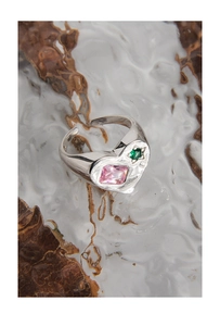 Macro view of S925 silver heart ring with pink and green zircon stones and wavy texture