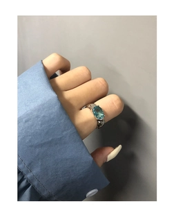 Close-up of S925 silver ring featuring a large oval blue zircon on a hand