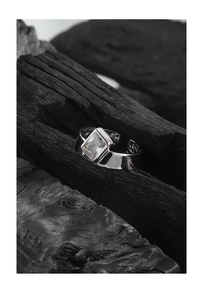 Dettaglio anello in argento S925 con zircone rettangolare su fondo in carboncino