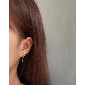 Minimalist liquid gold heart tassel earrings with melting effect on female model