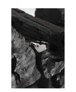 Detailed close-up of S925 silver heart ring with blue zircon inlay on charcoal background